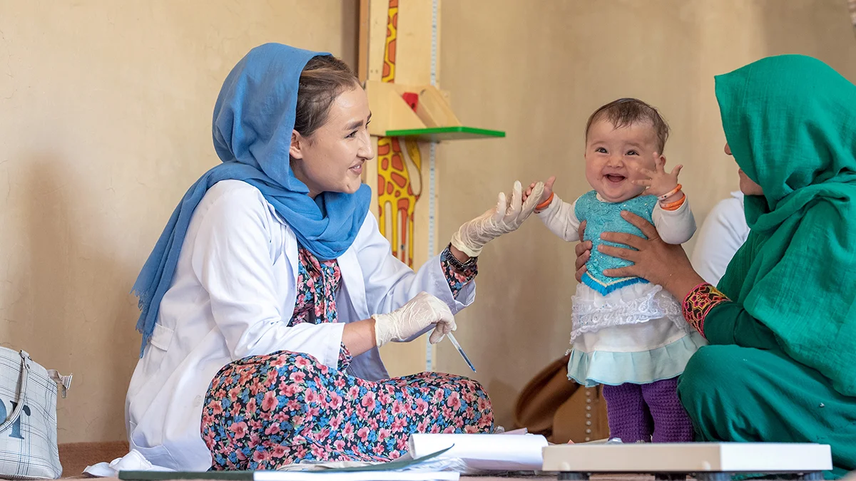 Eine Ernährungsberaterin des von UNICEF unterstützten mobilen Gesundheits- und Ernährungsteams untersucht ein Kind im der Provinz Daikundi in Zentralafghanistan.