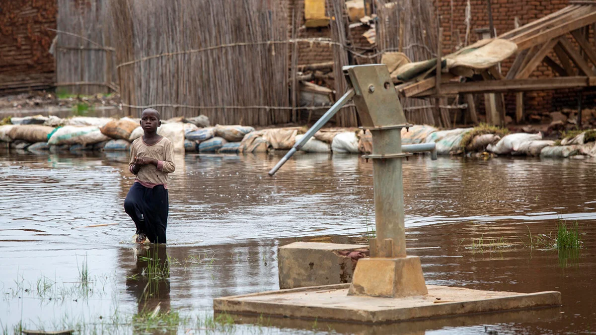 Un enfant marche à travers les inondations