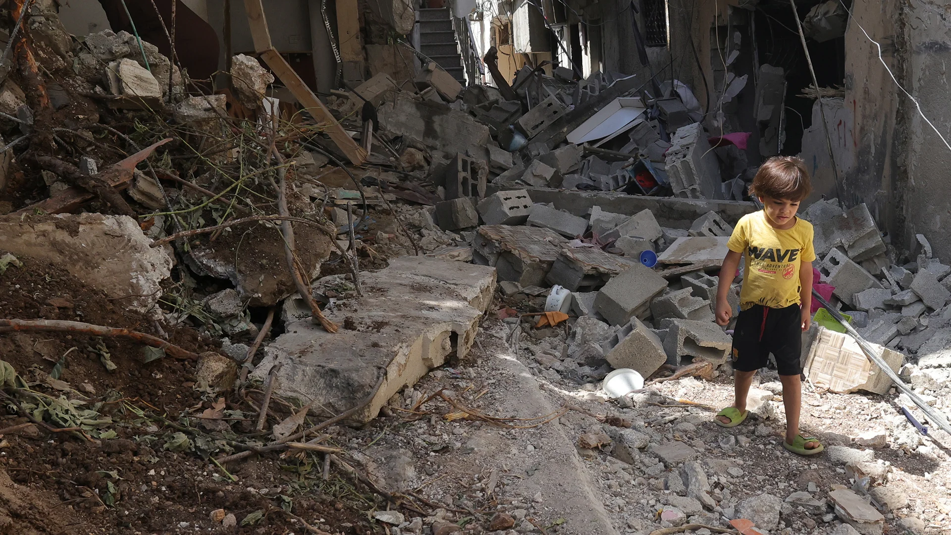 Ein Junge in Gaza läuft durch zerbombte Strassen.