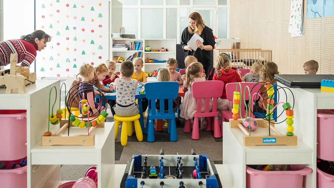 Des enfants sont assis à table dans un jardin d'enfants.