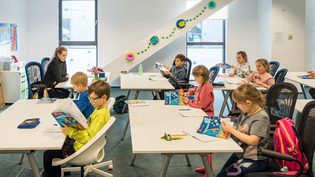 Des enfants sont assis dans une salle de classe.